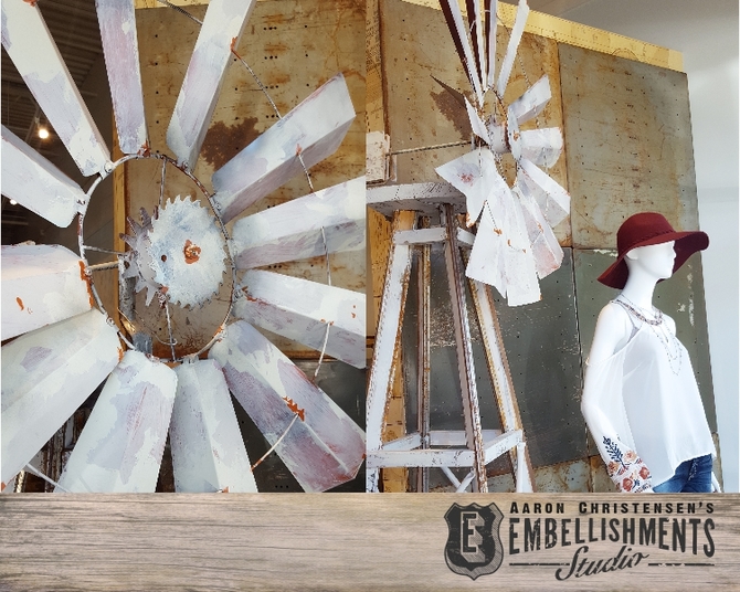 Reclaimed metal flashing, old packing crate parts, a garden hoe and scrap metal are transformed into a vintage look windmill by Aaron Christensen.  The piece serves as a window display pieces for an apparel boutique.